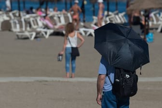 Ein Mann schützt sich vor der Sonne am Strand von Malaga, Spanien: Bereits Ende April erfuhr das Land eine Hitzewelle von bis zu 35 Grad. Jetzt sind es nochmals knapp 10 Grad mehr.