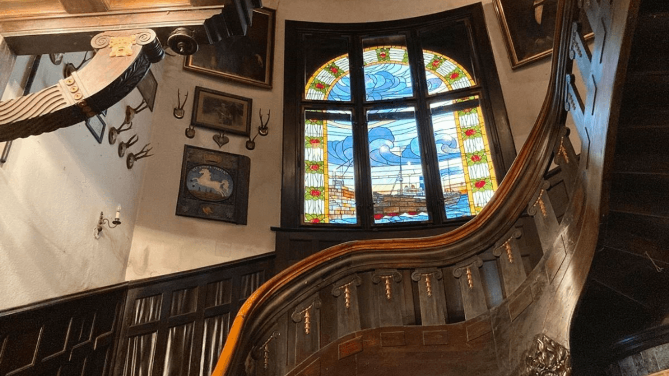 Verzierte Holzgeländer, historische Glasmalereien: Allein der Weg in die oberen Geschosse der Villa ist ein Blick wert.