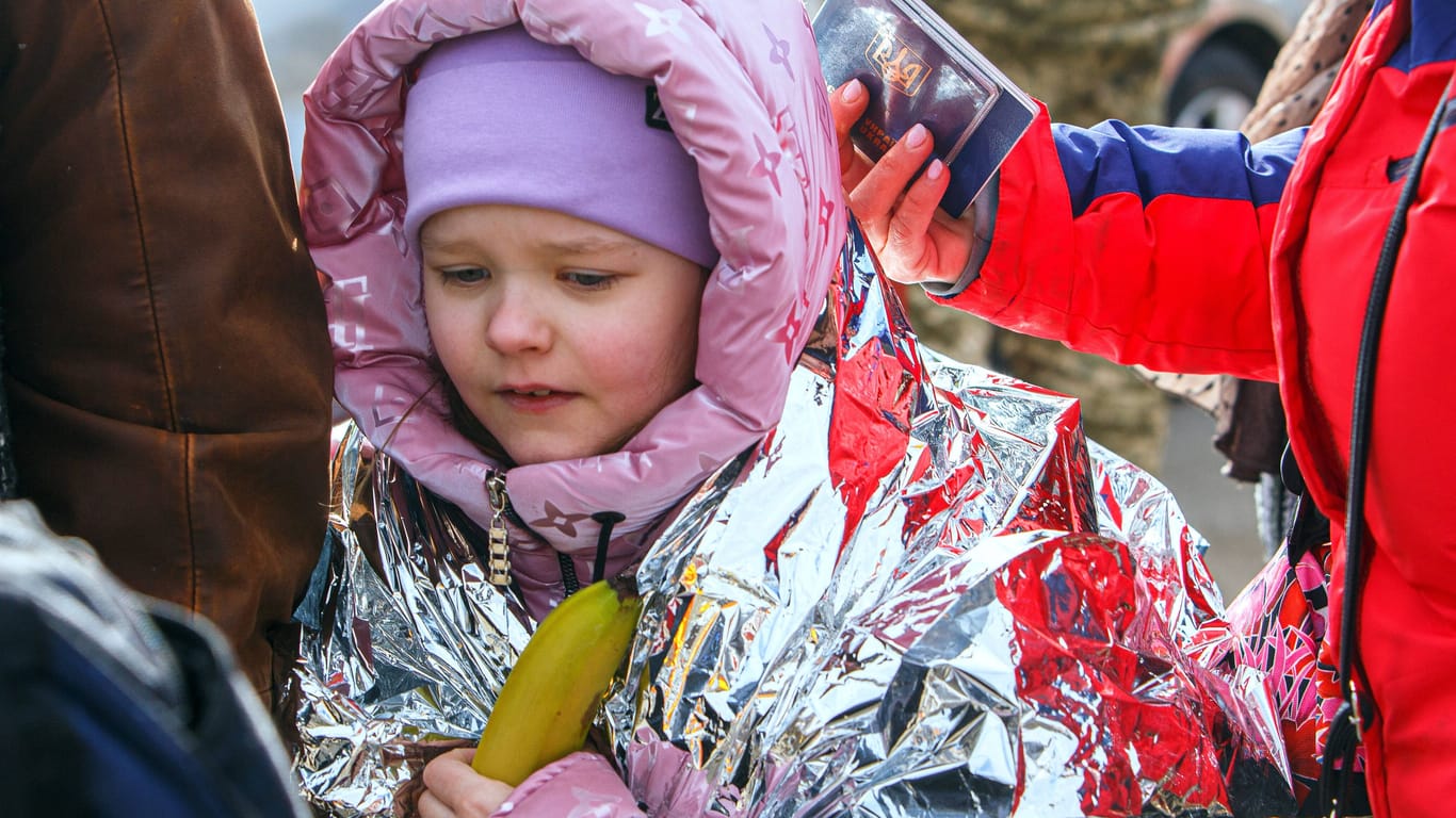 Ein ukrainisches Mädchen trägt auf der Flucht in die Slovakei eine Rettungsdecke zum Schutz gegen die Kälte. (Archivbild)