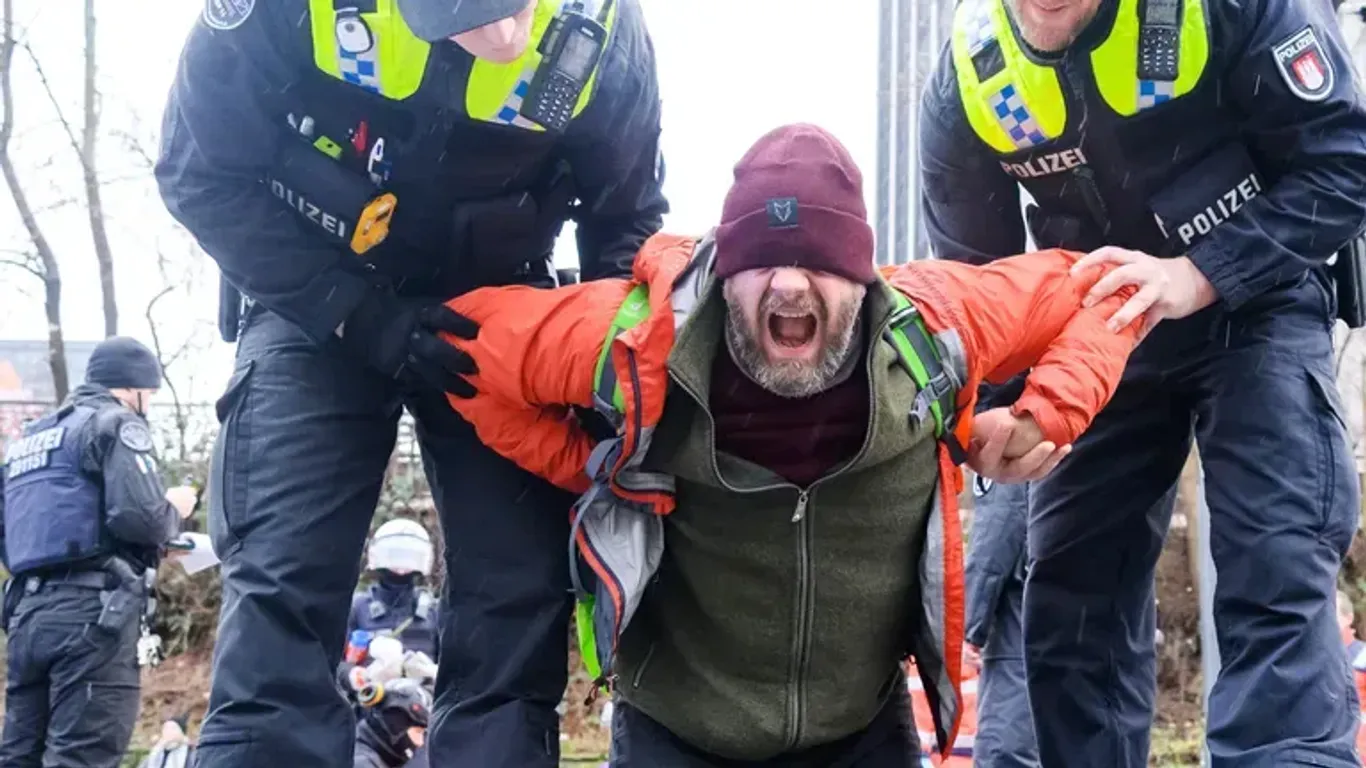 Ein Aktivist der "Letzten Generation" wird von Polizisten abgeführt: Der Protest kostet den Klimaaktivisten viel Geld.