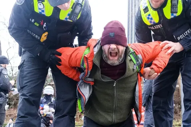 Ein Aktivist der "Letzten Generation" wird von Polizisten abgeführt: Der Protest kostet den Klimaaktivisten viel Geld.