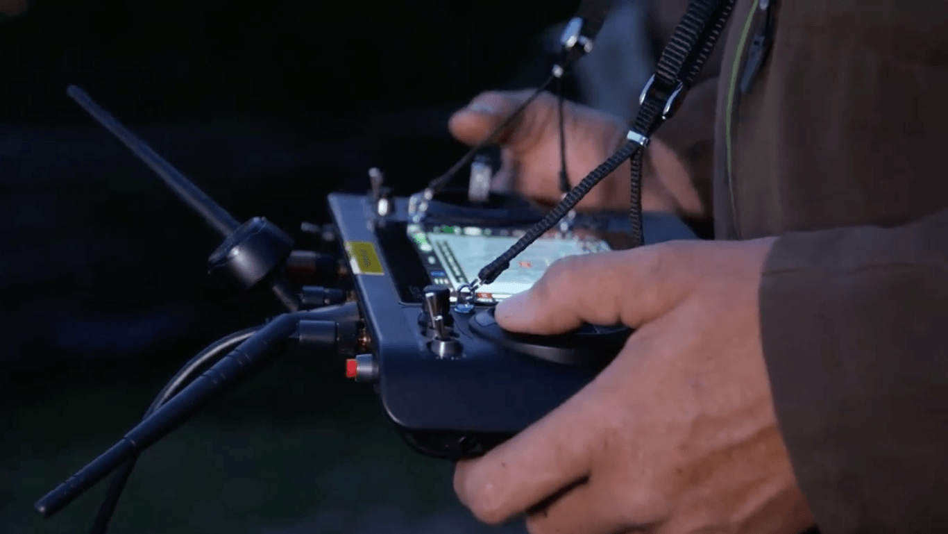Ein Drohnenpilot beobachtet auf einem Monitor die Bilder seiner Wärmebildkamera. Ein roter Fleck zeigt ein Tier an. Nun kann es vor dem Kreiselmäher gerettet werden.
