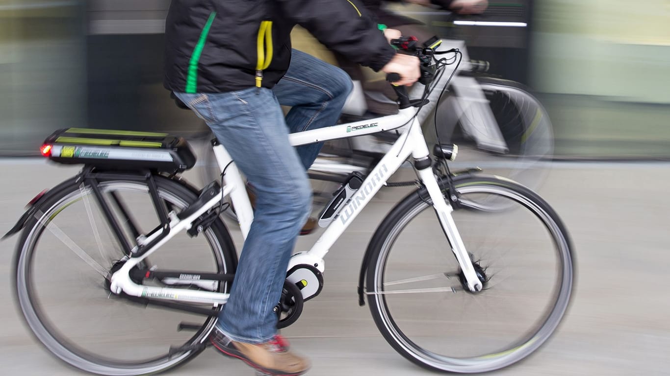 Ein Mann fährt auf einem Elektrofahrrad (Symbolbild): Wer mit einem E-Bike unterwegs ist, muss sich körperlich nicht so anstrengen wie beim Fahrradfahren.