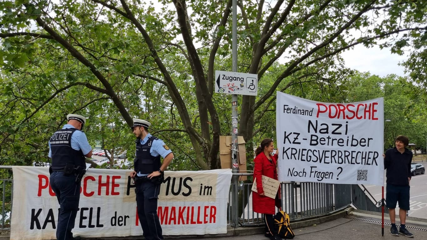 Am Rande der Hauptversammlung, demonstrieren Aktivisten gegen Porsche als Unweltsünder und KZ-Betreiber.