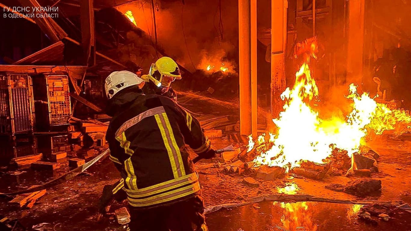 Feuerwehrleute in der ukrainischen Hafenstadt Odessa beim Löschen eines brandes, der durch russischen Raketenbeschuss entstanden ist.