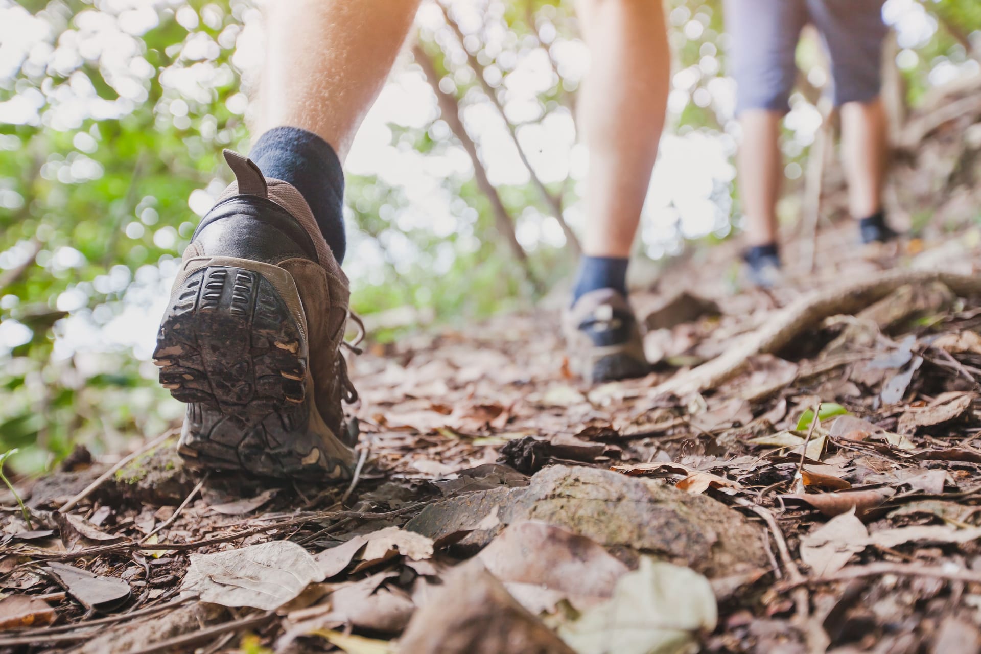 Wanderer auf Waldweg: Rote Flecken an den Beinen können auch mit Hitze zusammenhängen.