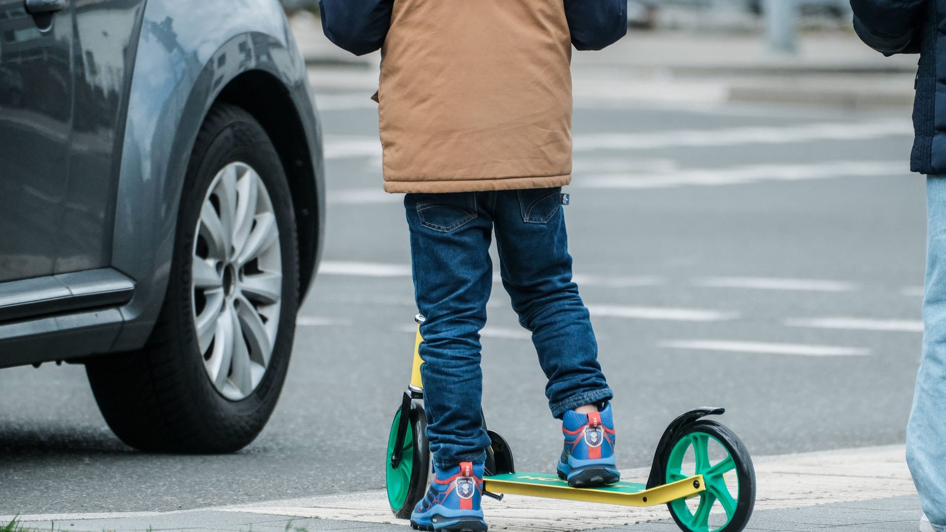 Ein Kind auf einem Tretroller: In Köln ist ein Kind von einem Auto erfasst worden.