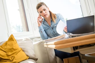Eine Frau telefoniert mit ihrer Versicherung (Symbolbild): Mit einer Hausratversicherung schützen Sie Ihr Hab und Gut vor Schäden.