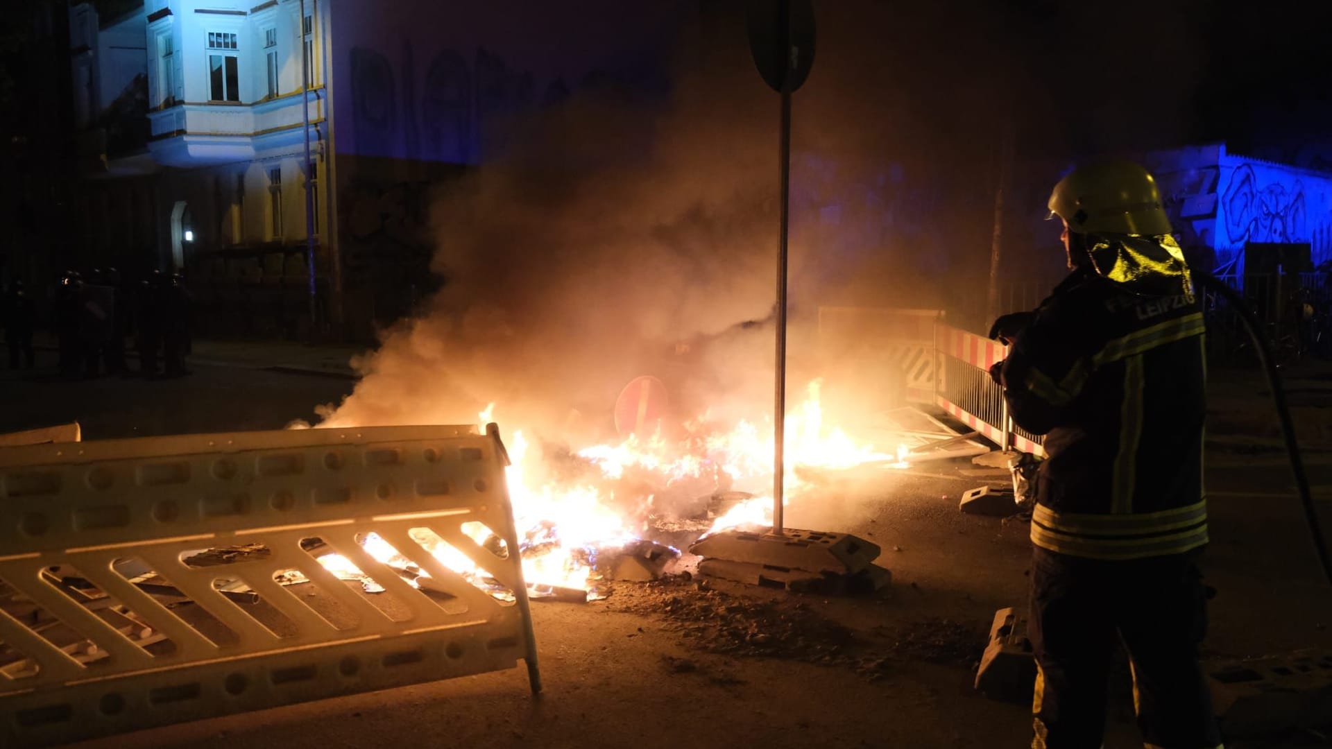 Feuerwehrleute löschen einen Brand nach den Ausschreitungen in Leipzig.