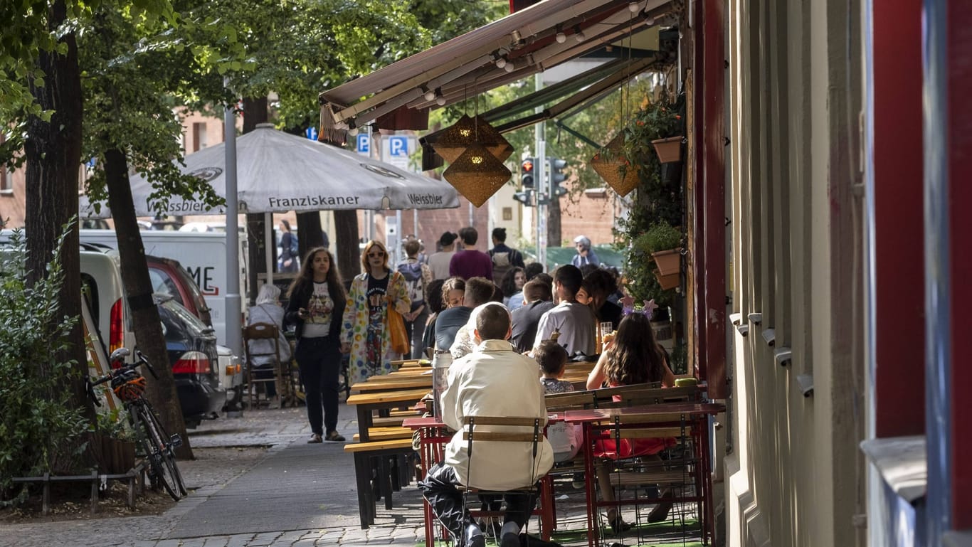 Besucher sitzen vor einem Café (Archivbild): In Kreuzberg können Gastronomen eine Entscheidung des Bezirks nicht verstehen.