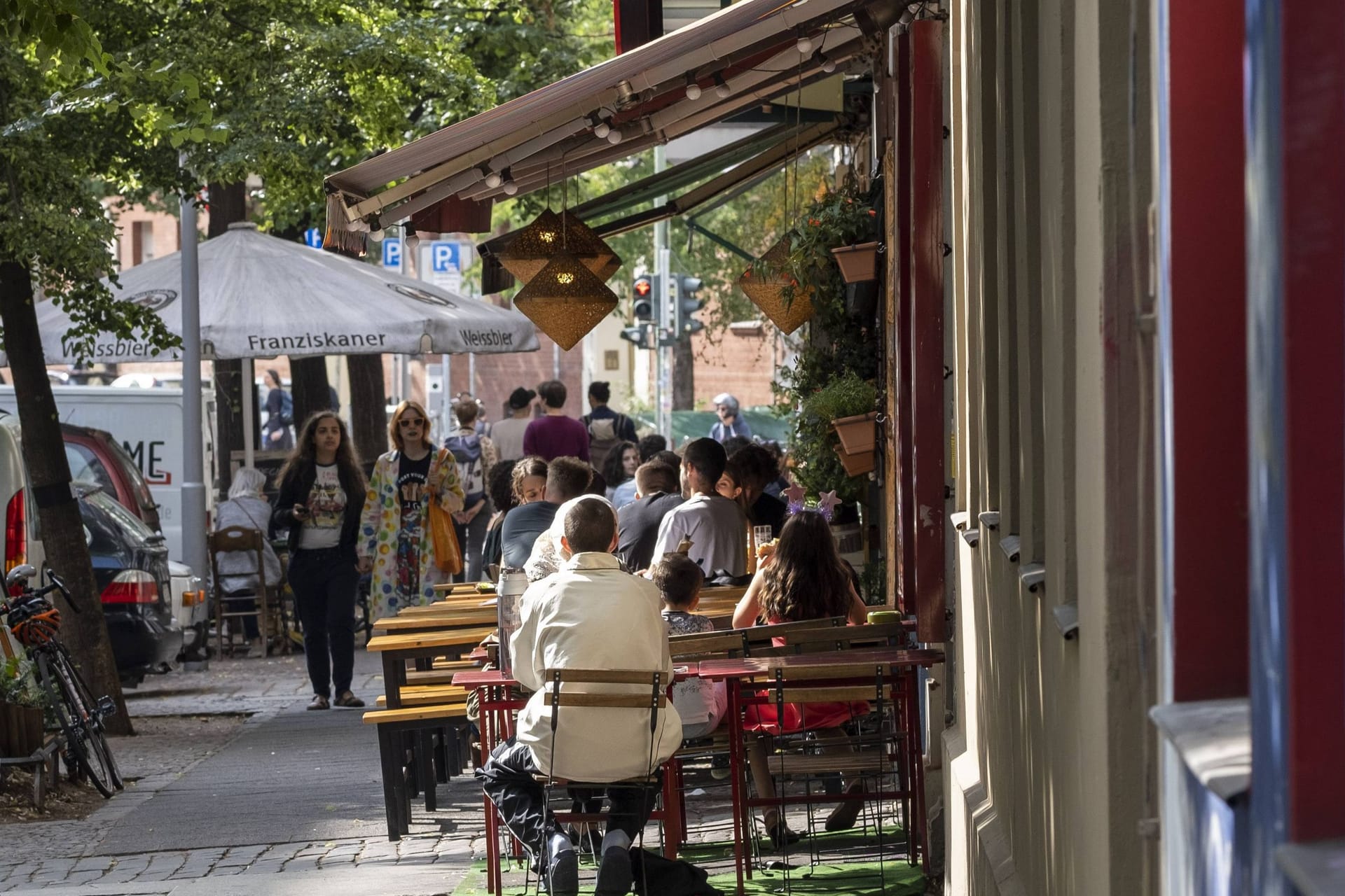 Besucher sitzen vor einem Café (Archivbild): In Kreuzberg können Gastronomen eine Entscheidung des Bezirks nicht verstehen.