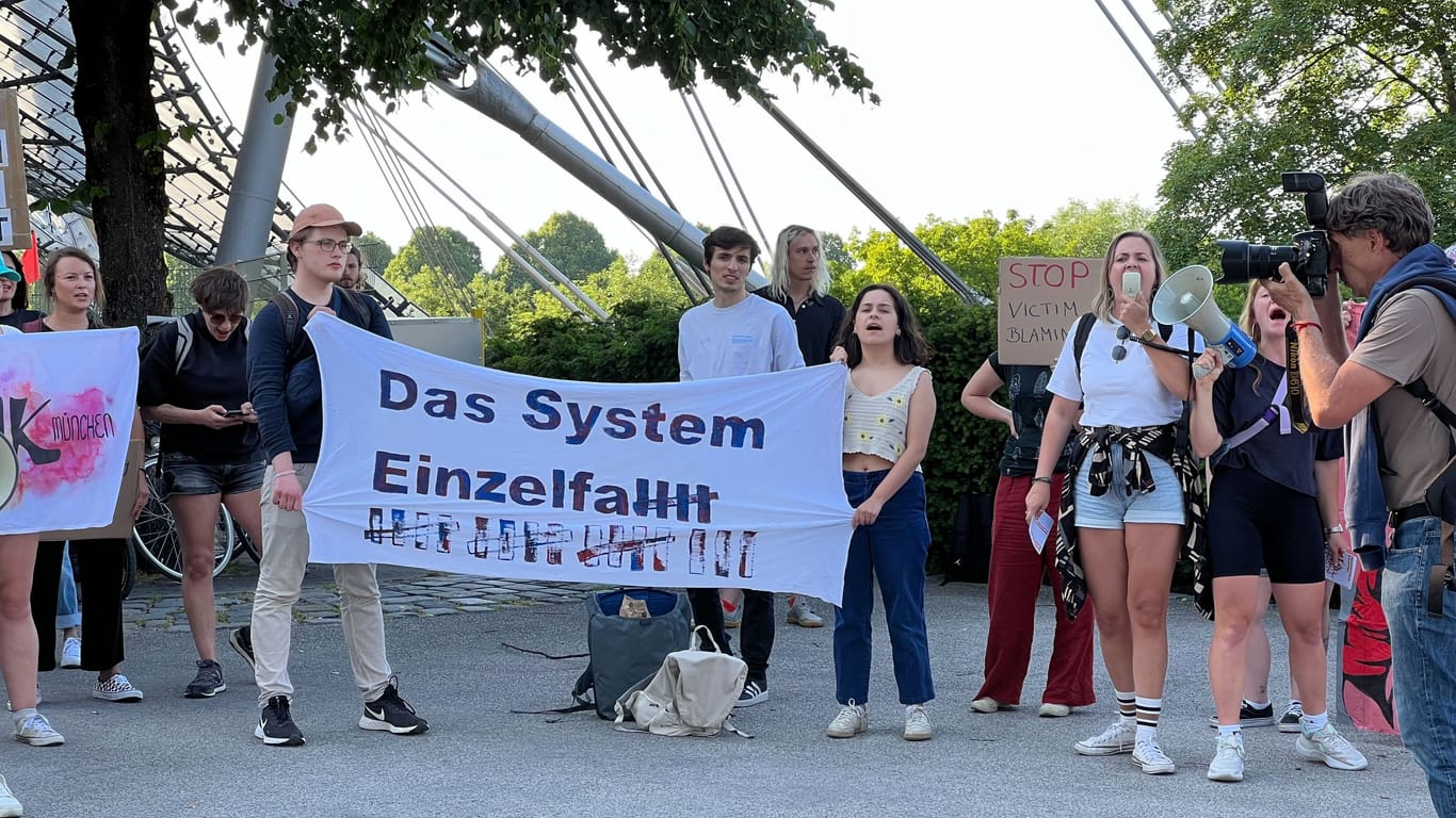 Demonstranten mit Bannern stehen vor dem Olympiastadion, wo am Mittwochabend das Rammstein-Konzert stattfinden soll.