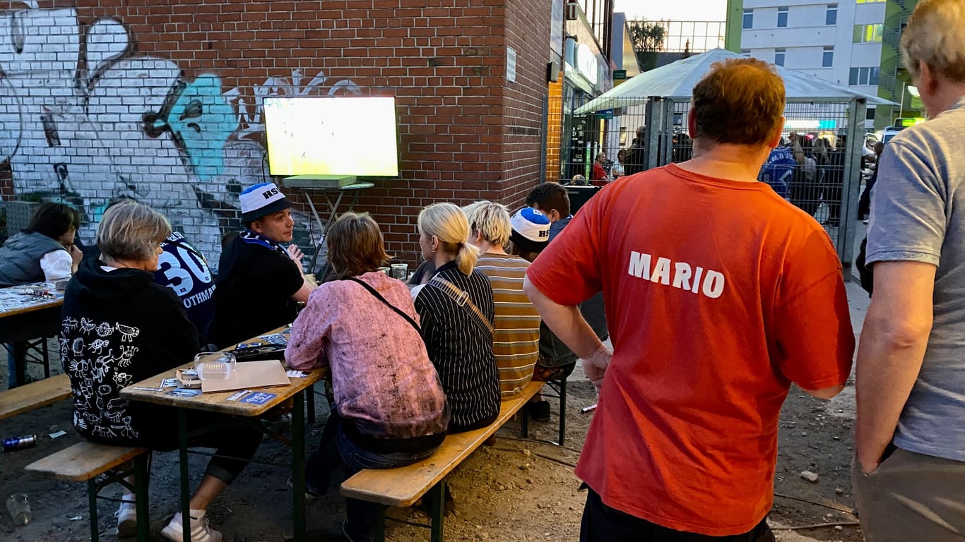 HSV-Fans und Kneipenwirt Mario Drifte verfolgen das Spiel vor dem Lokal: Die Hoffnung währte nur eine Halbzeit.