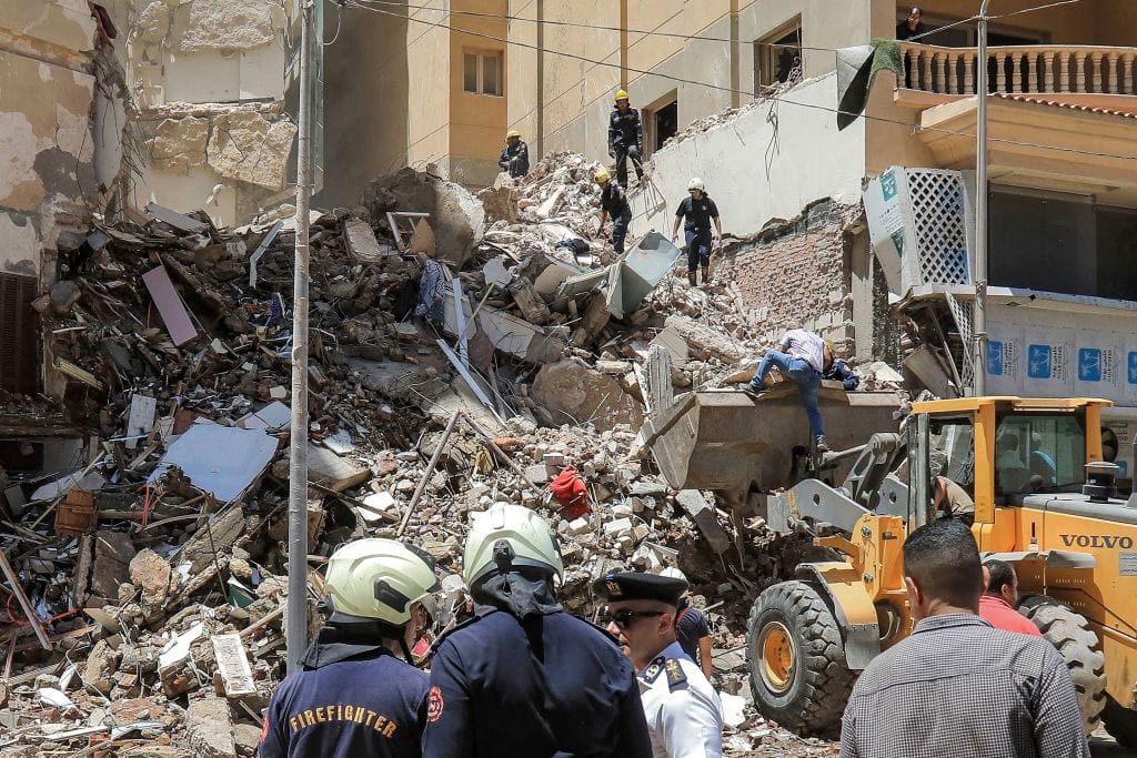 Menschen stehen vor dem zerstörten Gebäude in Alexandria: Die Suche nach Überlebenden geht weiter.