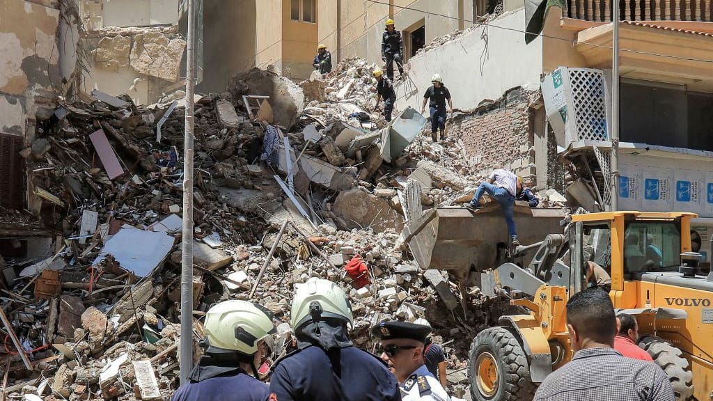 Menschen stehen vor dem zerstörten Gebäude in Alexandria: Die Suche nach Überlebenden geht weiter.