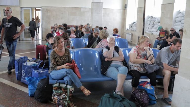 Menschen warten auf einen Evakuierungszug an einem Bahnhof in Cherson: Nach ukrainischen Angaben sind wohl 16.000 Menschen von der Überflutung betroffen.