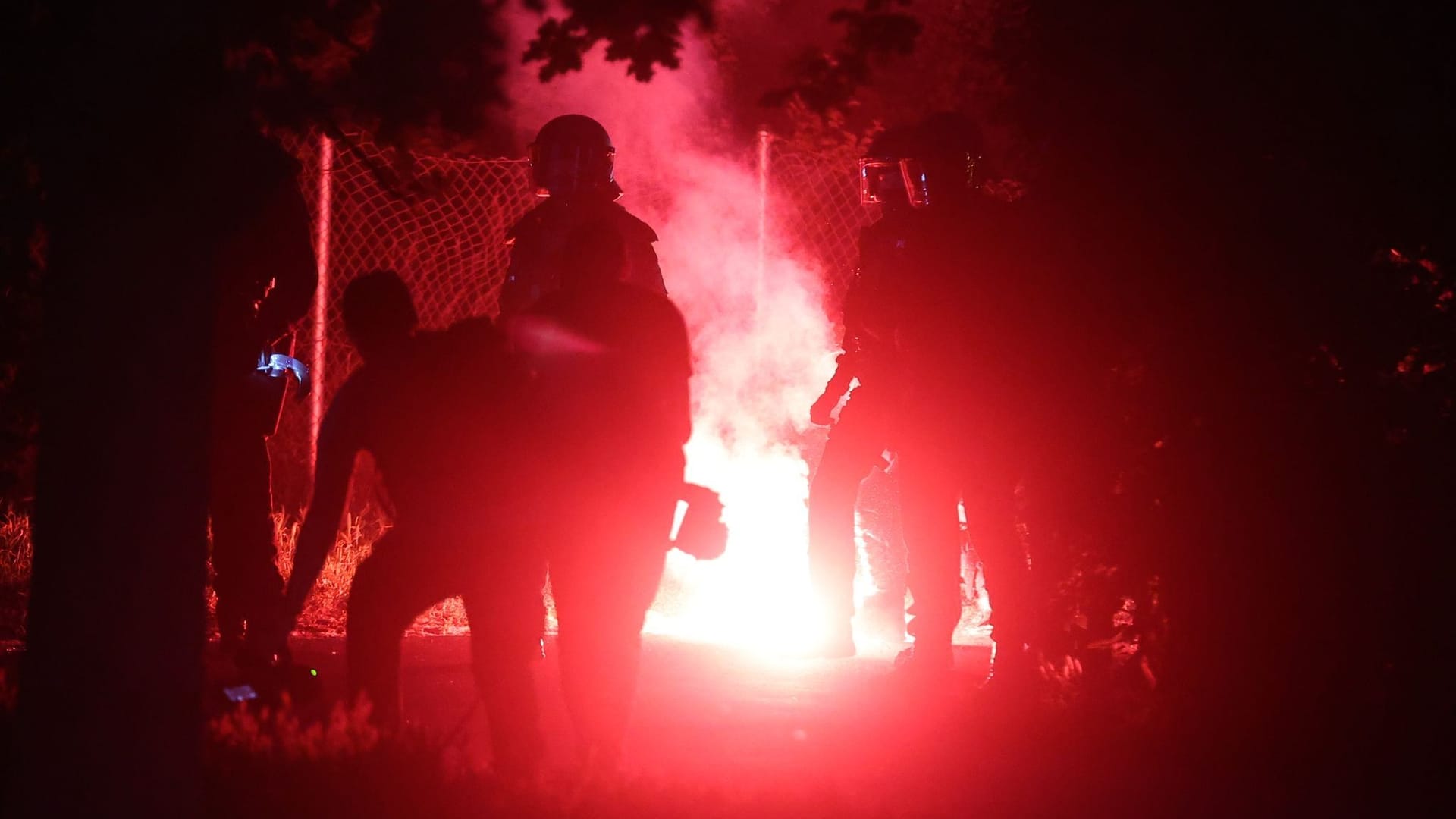 Polizisten werden von Demonstranten in einem dunklen Leipziger Park mit Pyrotechnik angegriffen.