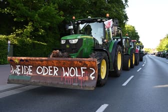 "Weide oder Wolf?" steht am Rande der Veranstaltung an einer Pflugschaufel eines Traktors: Die Demonstranten fordern einen restriktiveren Umgang mit Wölfen.