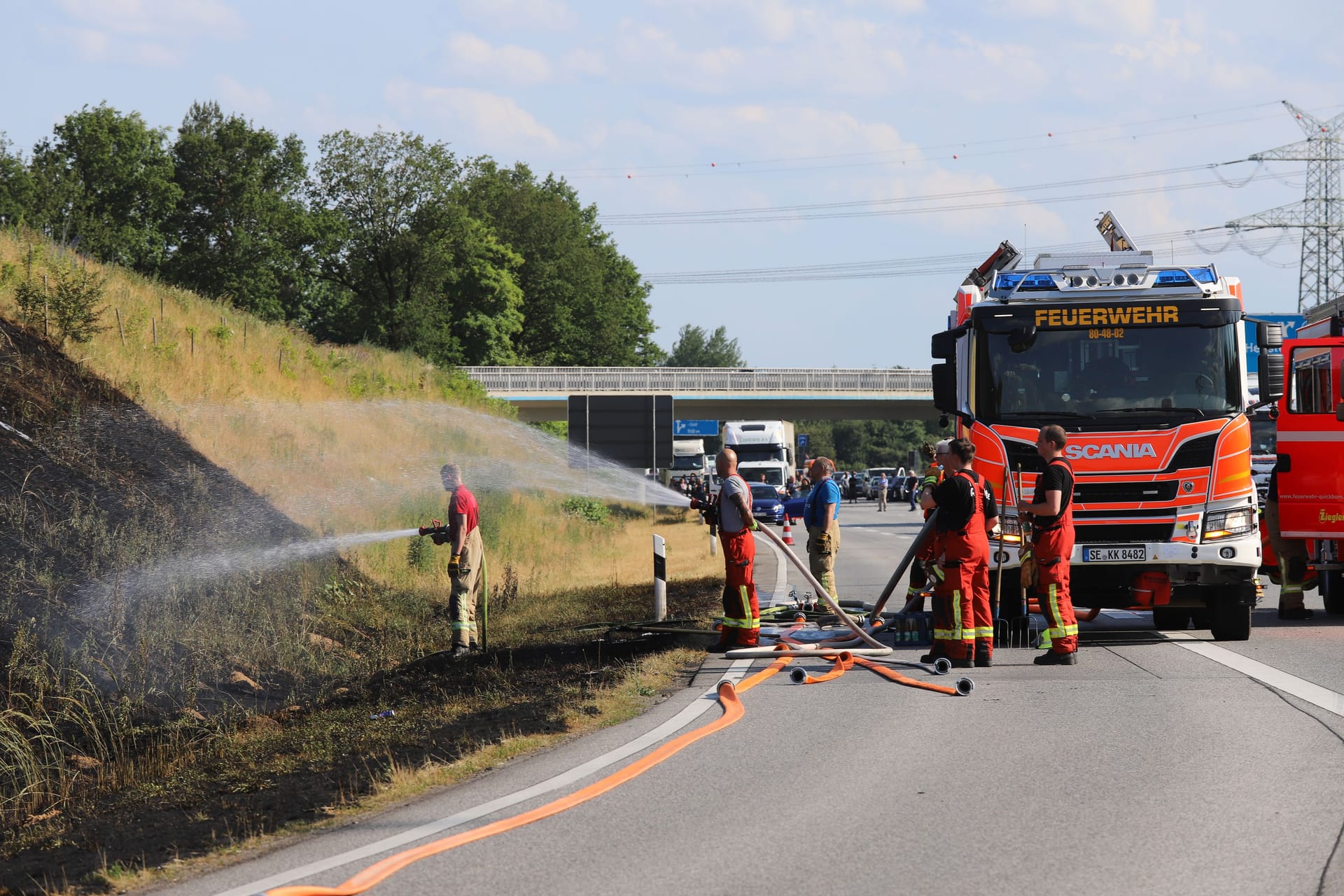 Einsatzkräfte der Feuerwehr löschen den Brand an der A7: Die Autobahn wurde zunächst in beide Richtungen gesperrt.