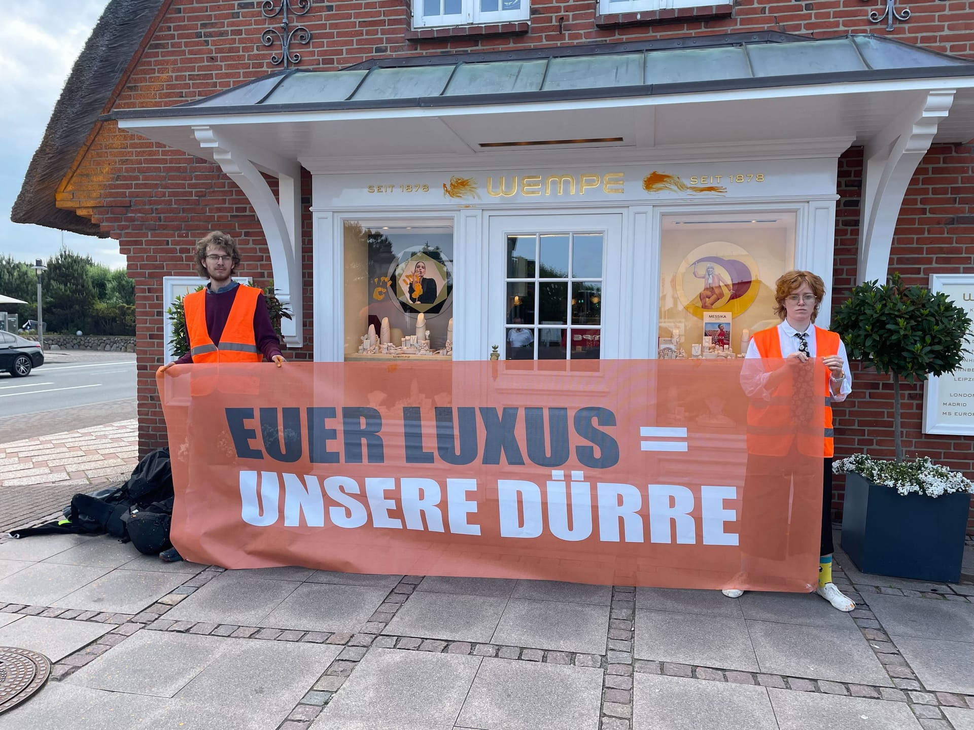 Davor positionierten sich die Aktivisten mit einem Plakat, auf dem "Euer Luxus = unsere Dürre" steht.