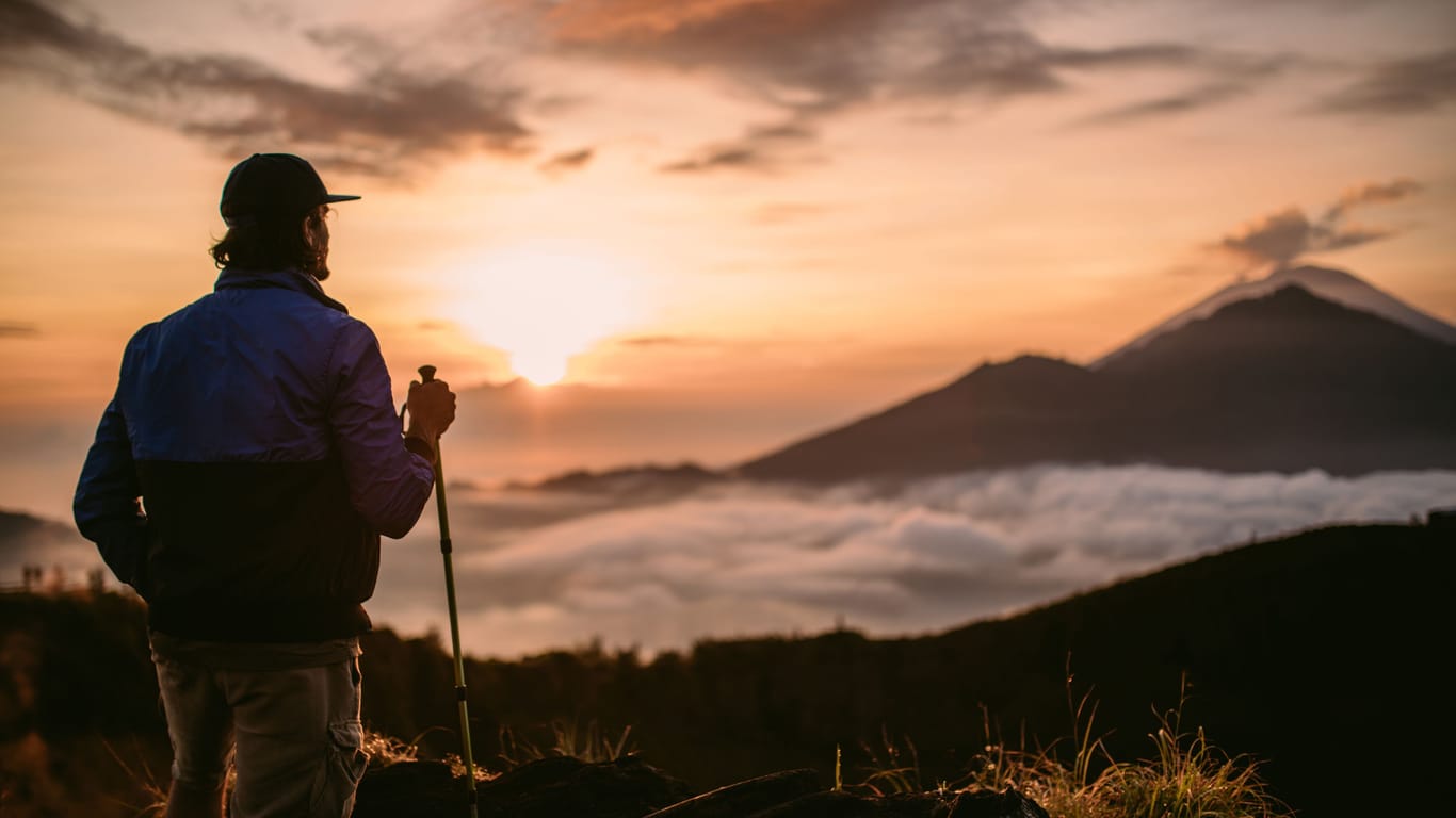 Eine Person genießt die Aussicht auf den Mount Batur: Touristen müssen die heiligen Orte im Ausland respektieren.