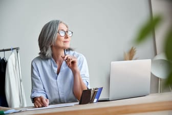Ältere Frau am Arbeitsplatz (Symbolbild): Wann kann ich eigentlich in Rente gehen? Ein Rechner kann bei der Kalkulation des möglichen Renteneintritts helfen.