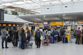 Passagiere stehen in München an der Gepäckabgabe. (Symbolbild)