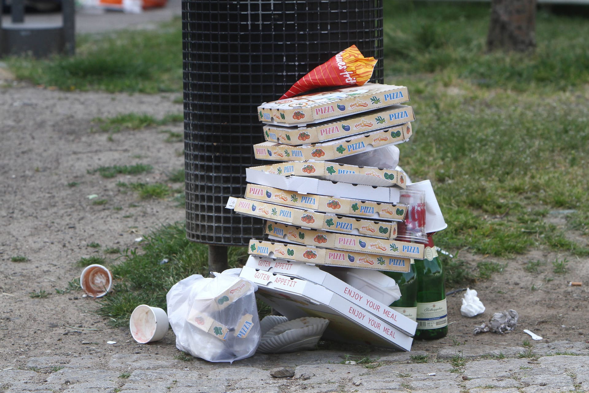 Pizzaschachteln stapeln sich neben geleerten Sektflaschen: Nach einem Wochenende im Sommer türmt sich in Köln vielerorts der Müll.