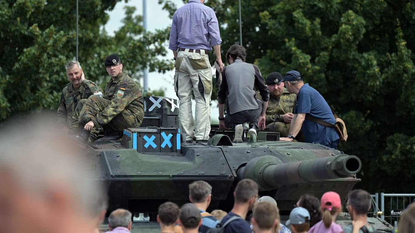 Besucher des "Tag der Bundeswehr 2023" schauen sich einen Leopard-2 Panzer an. Am Rande des Events kam es zu Protesten.