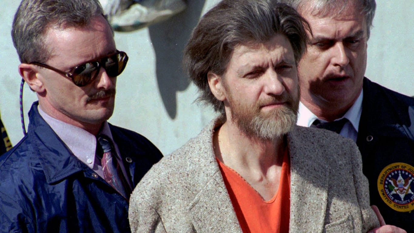 Ted Kaczynski wird 1996 auf dem Weg aus einem Gerichtsgebäude von Ermittlern geführt: Nach mehr als 25 Jahren ist der als "Unabomber" bekannte Attentäter nun in Haft verstorben.