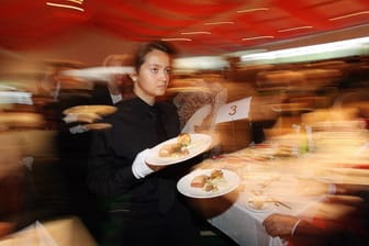 Kellnerin serviert in einem noblen Restaurant: Angestellte in der Gastronomie könnten mit am meisten vom Mindestlohn profitieren. (Quelle: Imago)