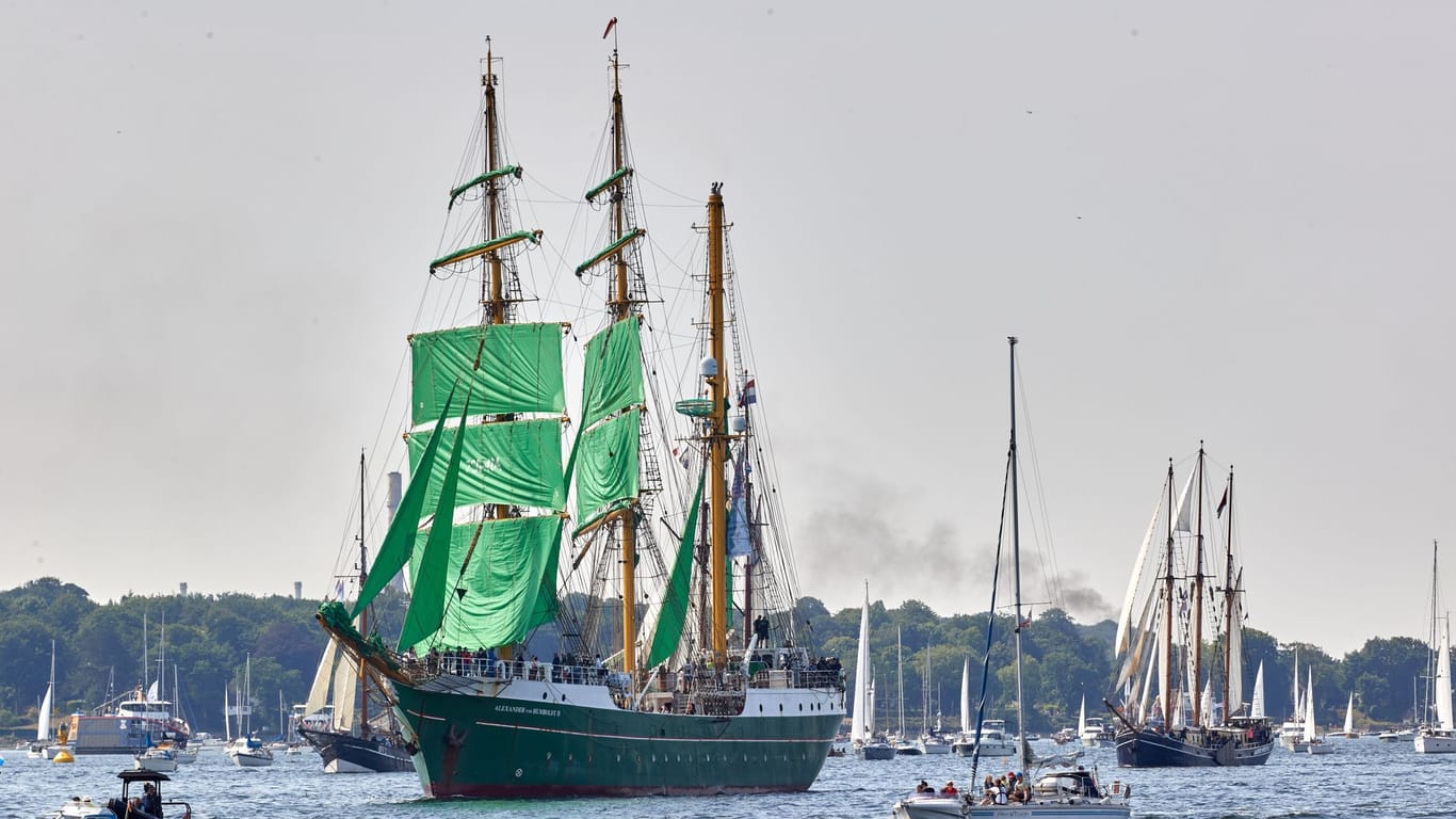 Angeführt vom Segelschulschiff "Alexander von Humboldt II" fahren Boote, Segler und Traditionssegler bei der Windjammerparade der Kieler Woche auf der Förde.