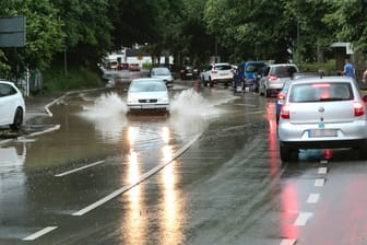Autos fahren über überschwemmte Fahrbahnen (Symbolbild): In Soest musste die Feuerwehr bis zu 20 Einsätzen ausrücken.