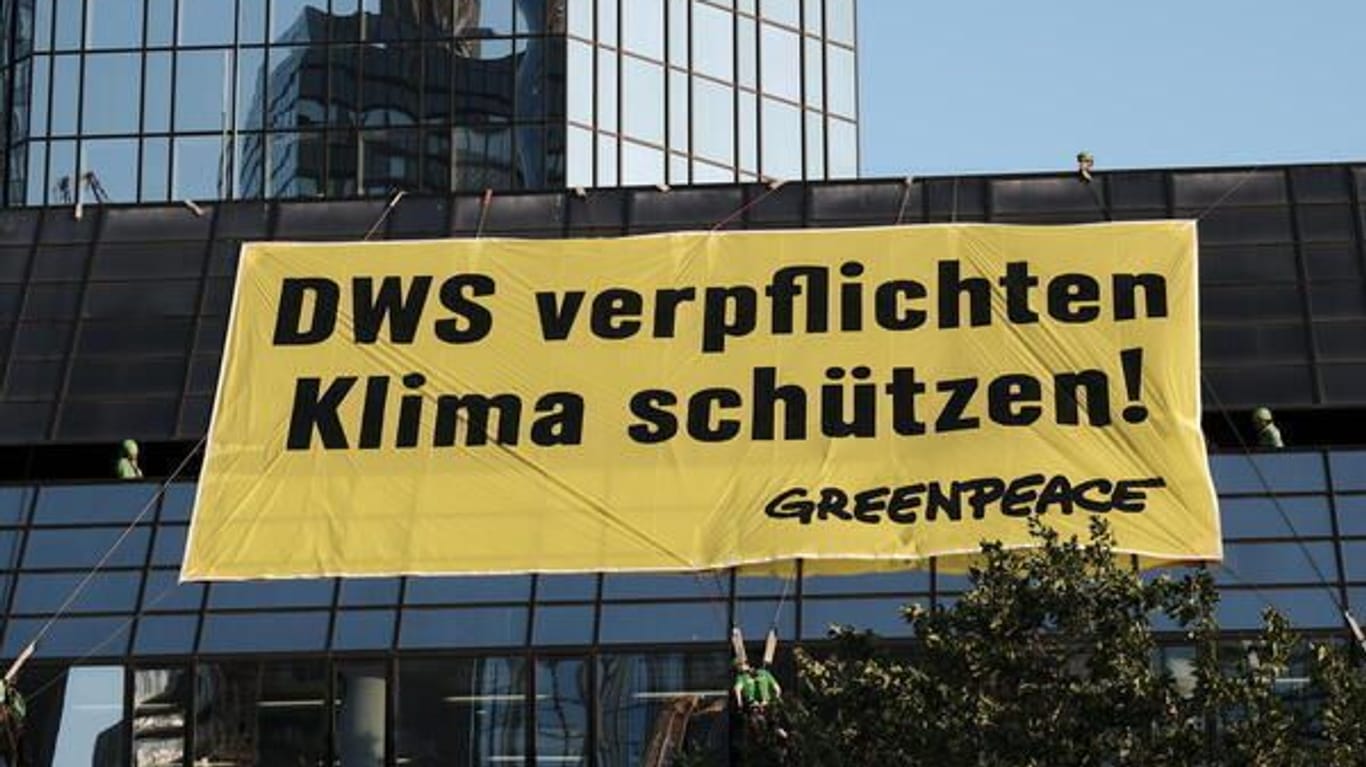 „DWS verpflichten, Klima schützen“ fordern Greenpeace-Aktivisten mit einem rund 100 Quadratmeter großen Banner an der Zentrale der DWS-Konzernmutter Deutsche Bank in Frankfurt.