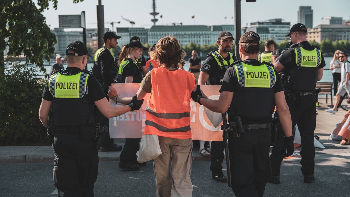 Polizisten führen einen Aktivisten der "Letzten Generation" in Hamburg ab.
