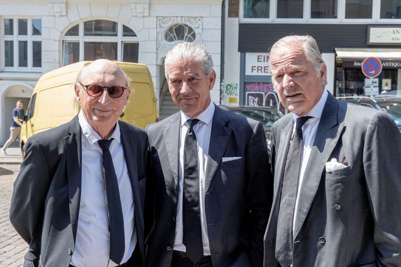 Der Komiker Otto Waalkes (l-r), Christian Völkers, Immobilienmakler, und der Gutsbesitzer Enno von Ruffin stehen vor Beginn des Trauergottesdiensts für Bertram Rickmers vor der Hauptkirche St. Michaelis.