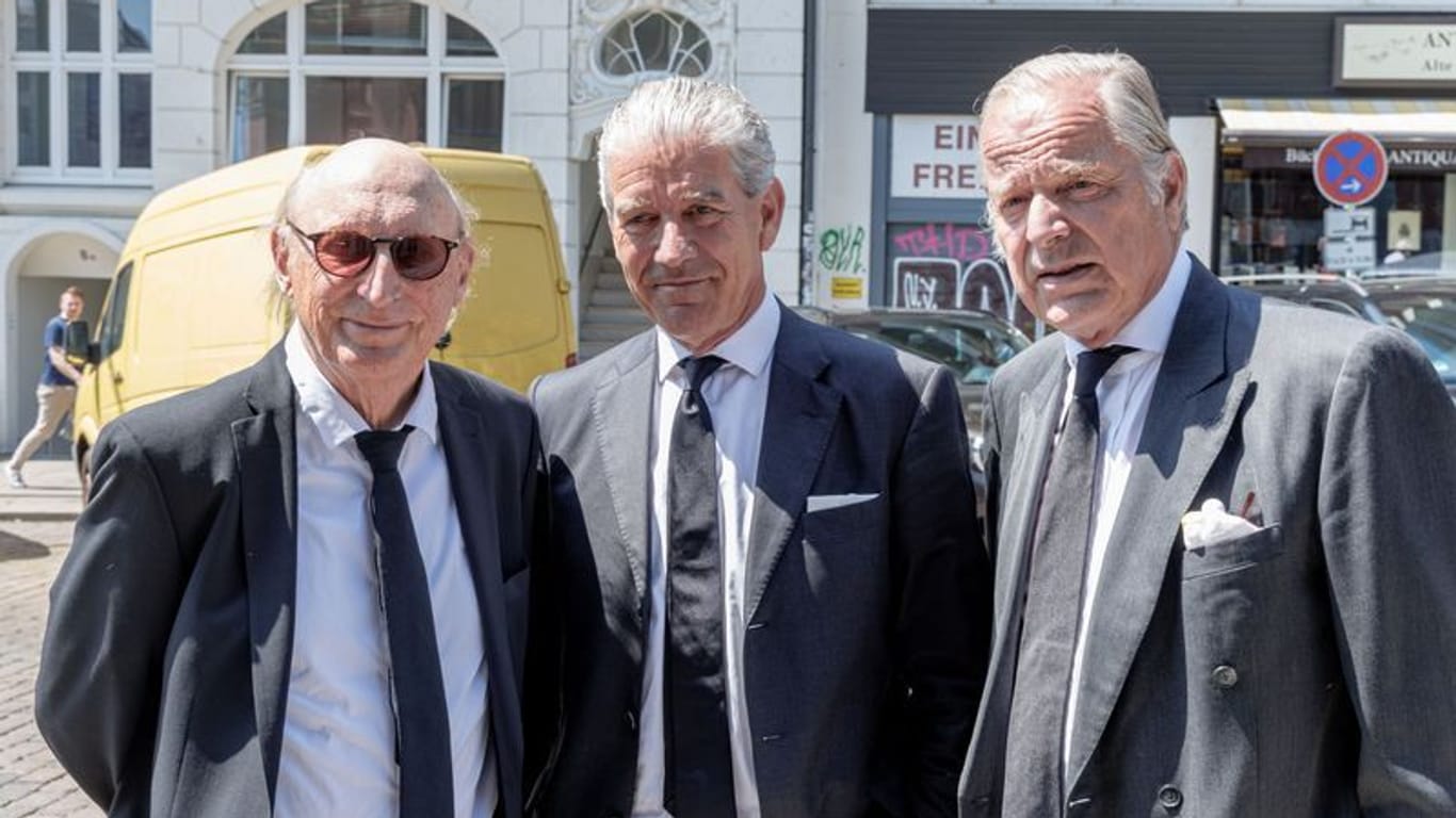 Der Komiker Otto Waalkes (l-r), Christian Völkers, Immobilienmakler, und der Gutsbesitzer Enno von Ruffin stehen vor Beginn des Trauergottesdiensts für Bertram Rickmers vor der Hauptkirche St. Michaelis.