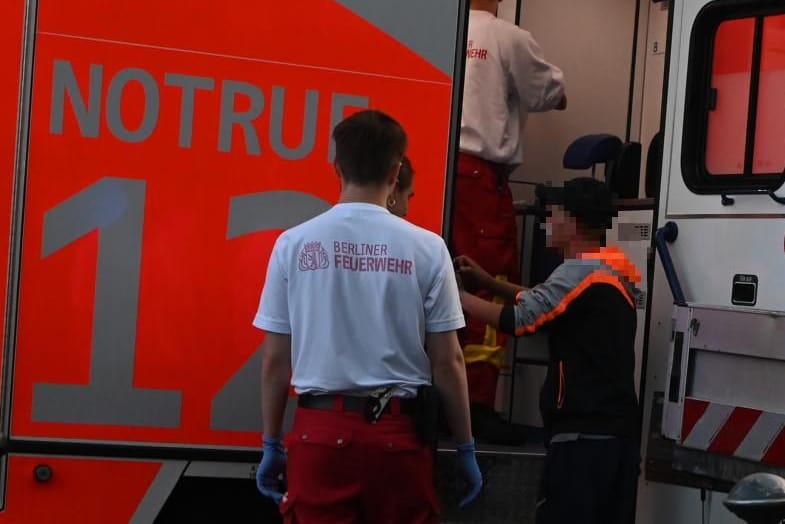 Ein Opfer des Messerangriffs spricht mit den Sanitätern am Kottbusser Tor.