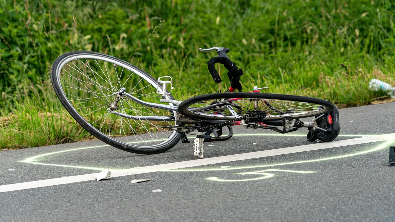 Ein Rennrad liegt auf einem Seitenstreifen (Symbolbild): In Feldafing ist ein Rennradfahrer bei einem Unfall schwer verletzt worden.