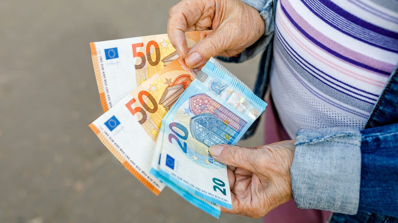 Rentnerin hält Euroscheine (Symbolbild): Rund 80 Prozent der Berechtigten lassen sich den Entlastungsbeitrag der Pflegeversicherung entgehen.