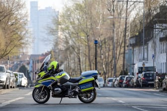 Ein Polizeimotorrad versperrt die Straße (Symbolbild): Nach dem Fund eines schwer verletzten Kölners in Nippe hat die Polizei neue Erkenntnisse.