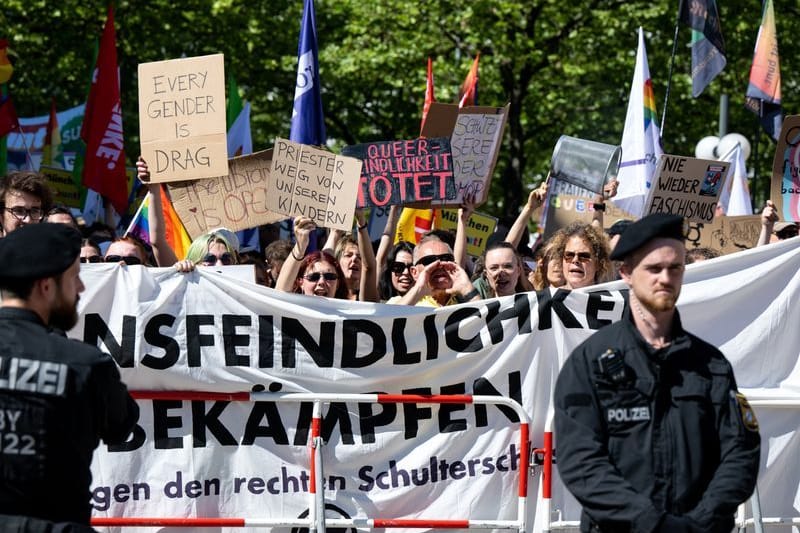 Teilnehmer einer Solidaritätsdemo stehen unter dem Motto "München ist bunt" vor Beginn der Lesung vor der Stadtteilbibliothek.