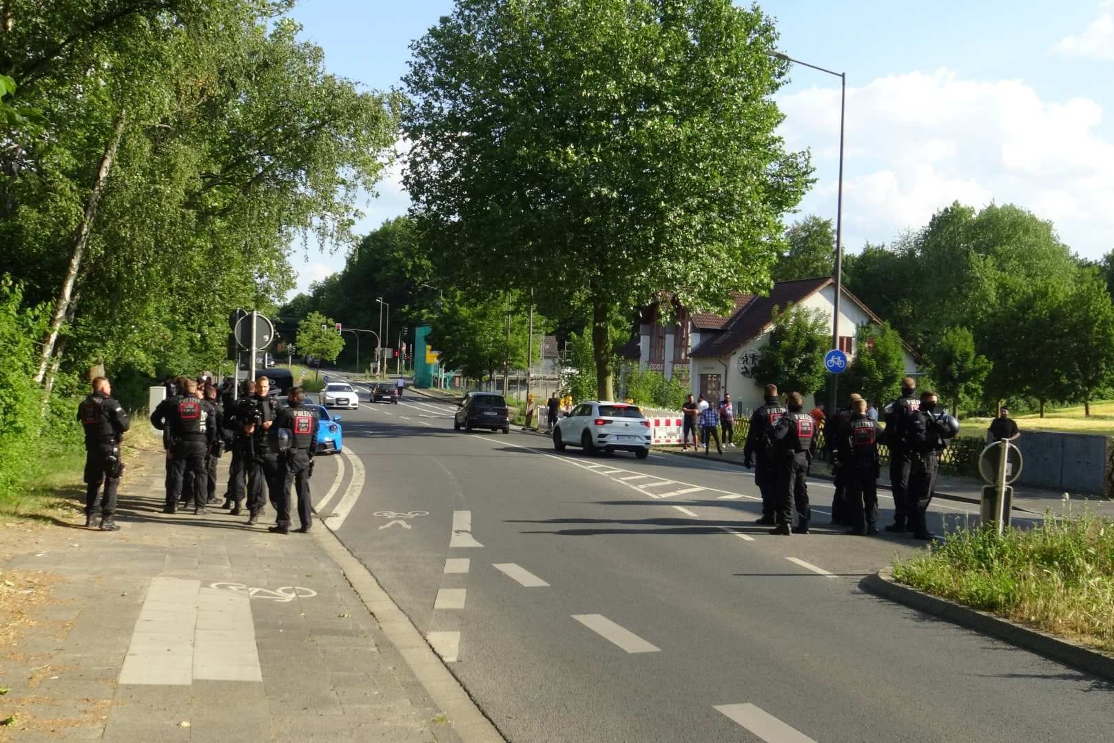 Polizisten stehen an der Straße, an der am Donnerstagabend die Prügelei stattgefunden hatte.