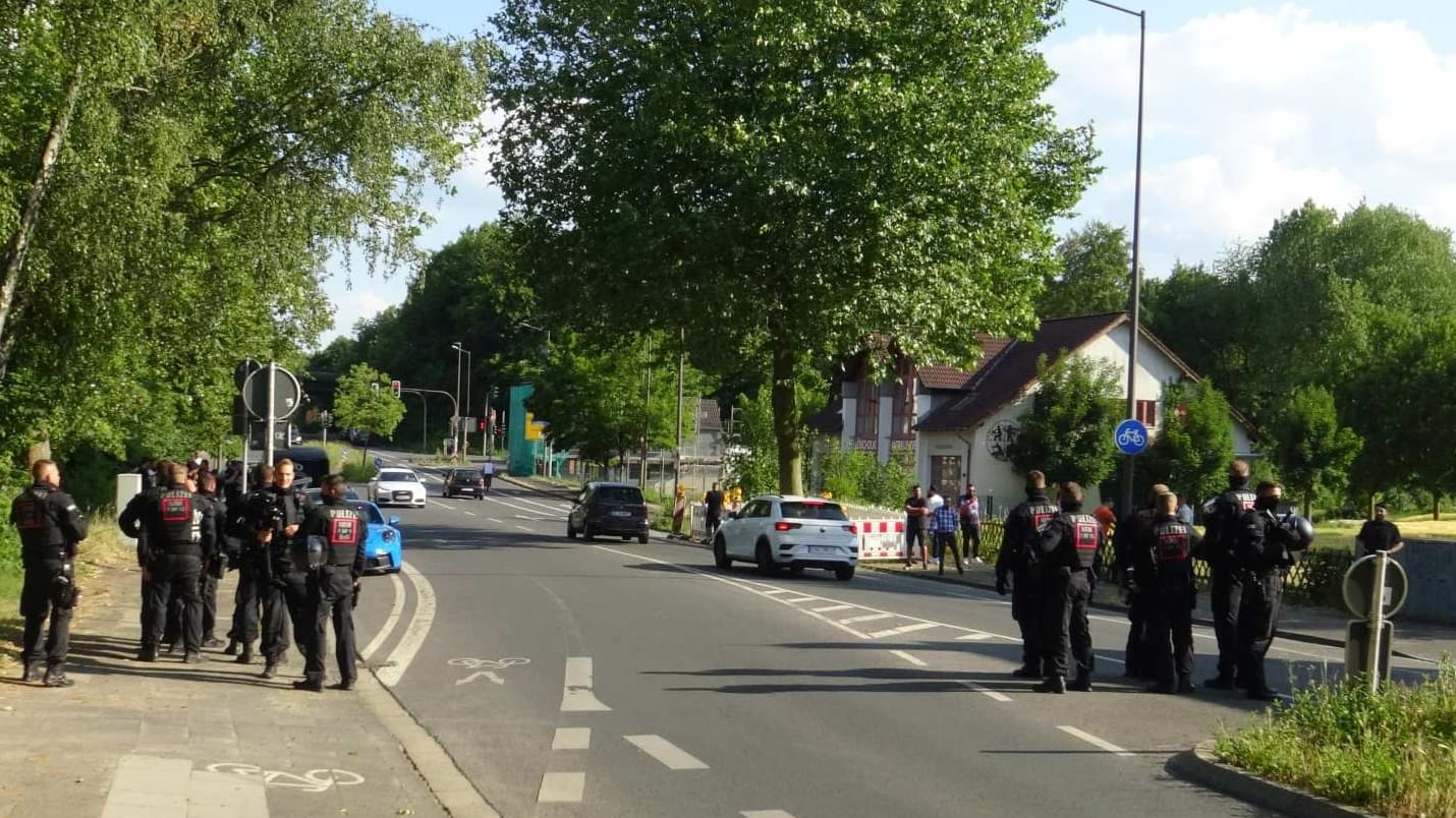 Polizisten stehen an der Straße, an der am Donnerstagabend die Prügelei stattgefunden hatte.