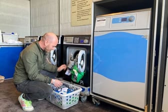 In der Waschküche: Achim Topf befüllt während des Festivals Rock am Ring eine Waschmaschine mit Hemden der Security-Mitarbeiter.