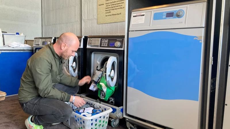 In der Waschküche: Achim Topf befüllt während des Festivals Rock am Ring eine Waschmaschine mit Hemden der Security-Mitarbeiter.