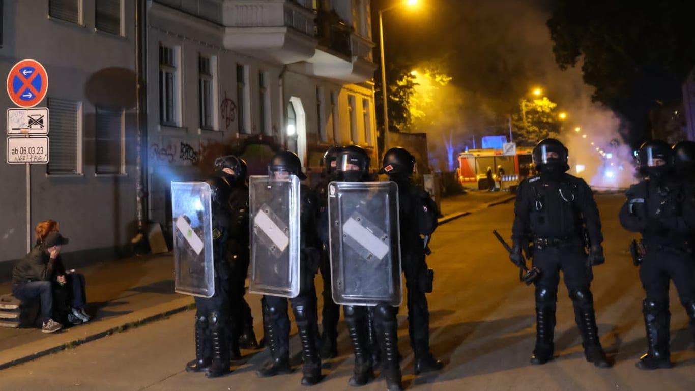 Polizisten in voller Ausrüsting sperren eine Straße in Leipzig ab. In der Nacht gab es Randale.