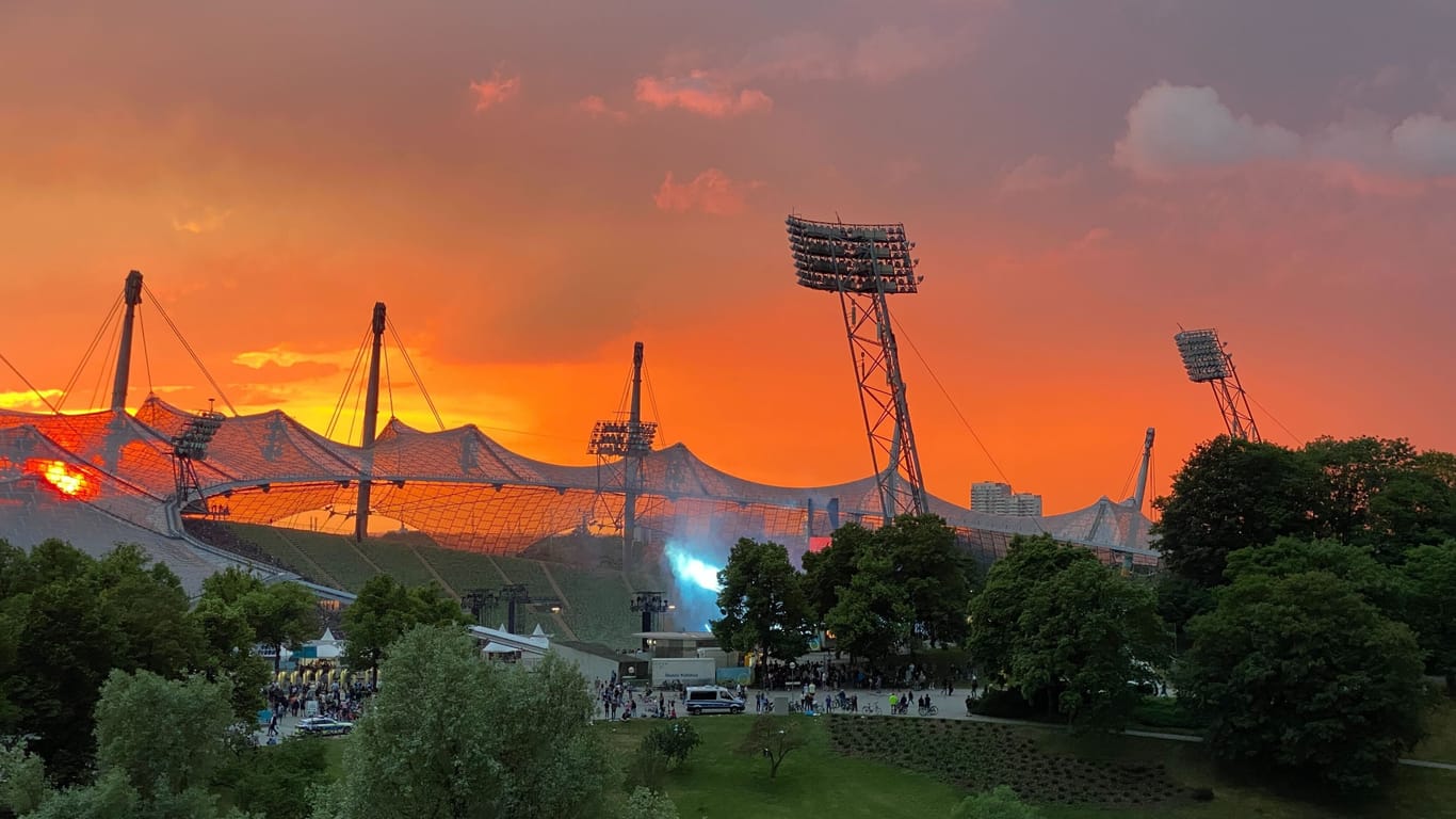 Über dem Olympiastadion zogen am Abend dunkle Wolken auf, über dem Stadion liegt Rauch.