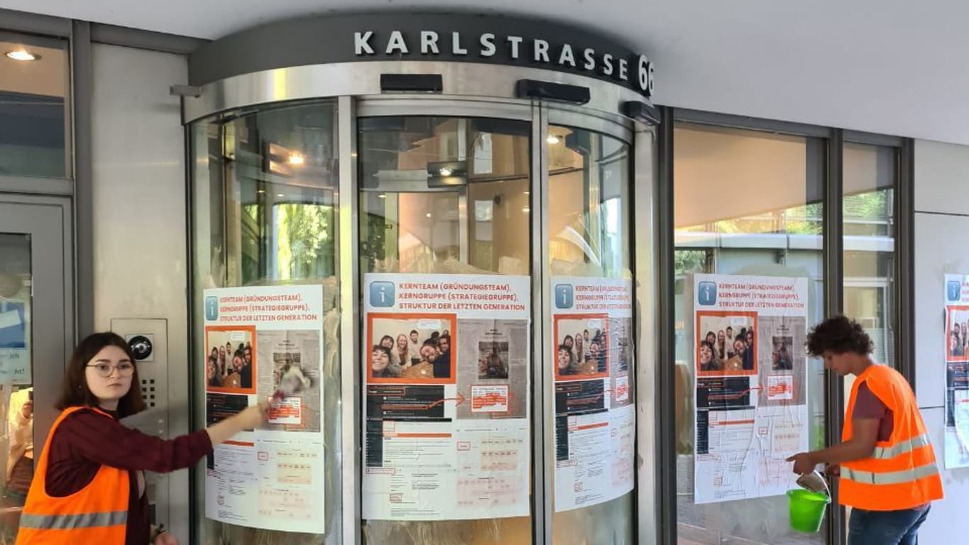 Aktivistinnen und Aktivisten bekleben den Sitz der Generalstaatsanwaltschaft mit Plakaten.