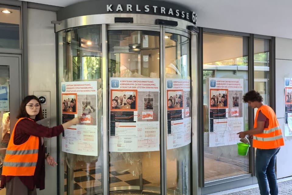 Aktivistinnen und Aktivisten bekleben den Sitz der Generalstaatsanwaltschaft mit Plakaten.